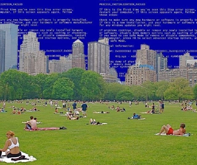 The meme is a screenshot of a Windows error message, specifically the infamous "Blue Screen of Death" (BSoD), overlaid on a picture of a crowded New York City park. The text at the top of the image reads "A fatal error has occurred. The system has been shut down to protect your computer." The image is humorous because it takes a serious and technical error message and applies it to a mundane and peaceful scene, creating an absurd and humorous contrast.